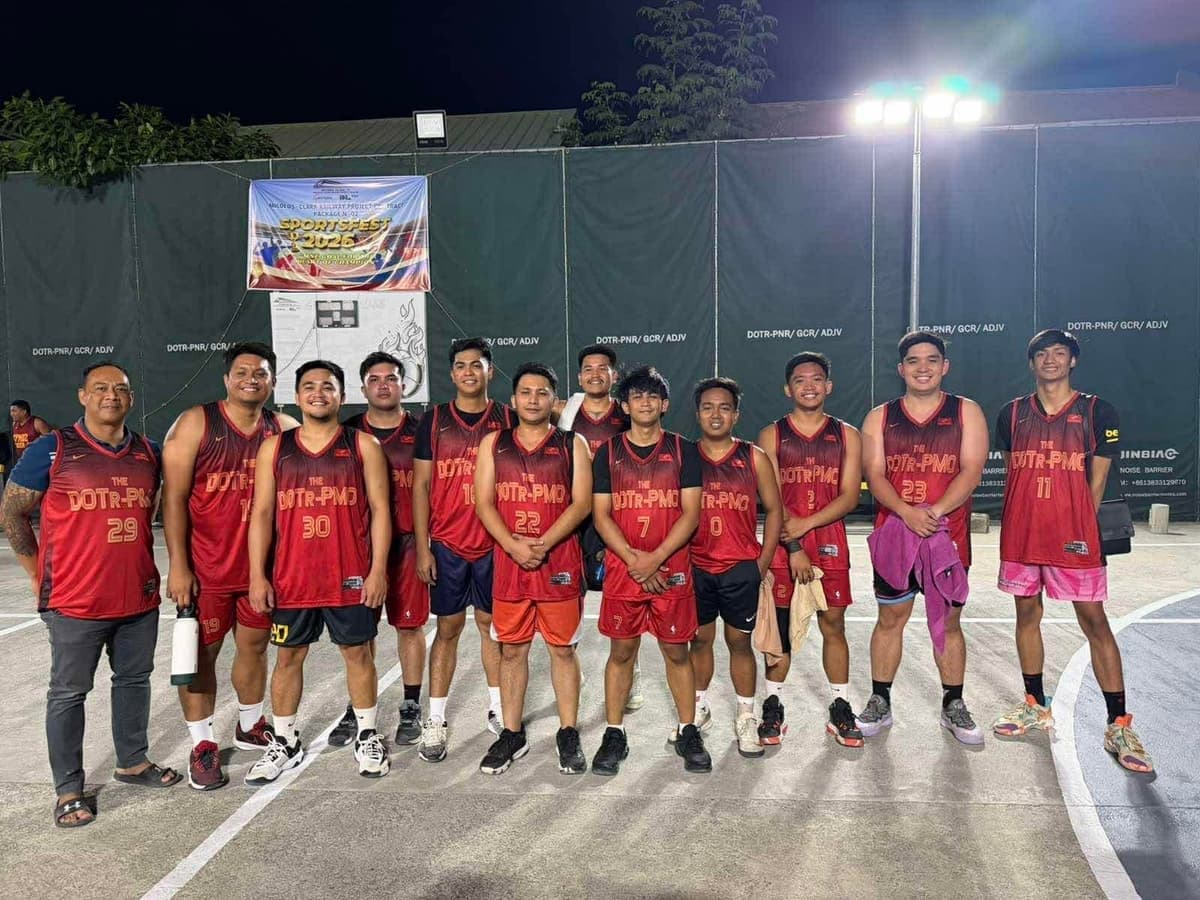 DOTr-PMO team in maroon jerseys on a floodlit outdoor court